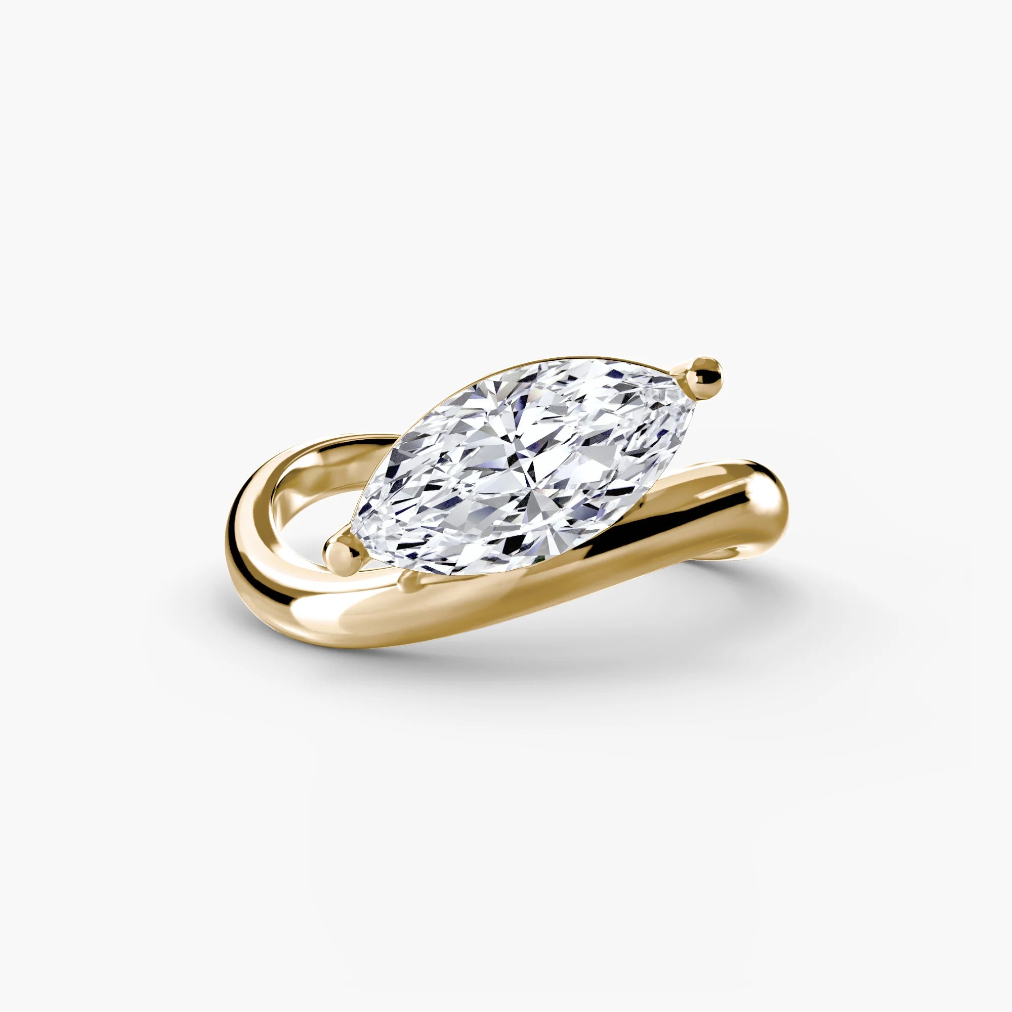 Gold ring with a pear-shaped diamond on a white background