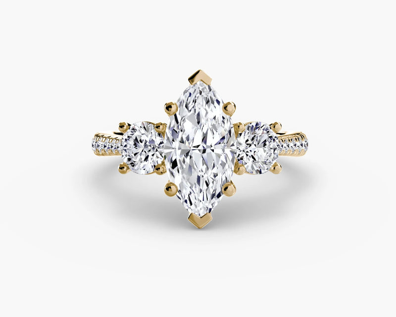 Gold ring with a pear-shaped diamond on a white background