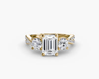 Rose gold ring with emerald-cut diamond and smaller round diamonds on a white background