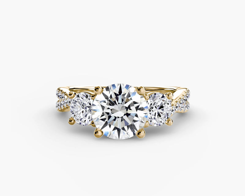 Gold ring with a large central diamond and smaller side diamonds on a white background