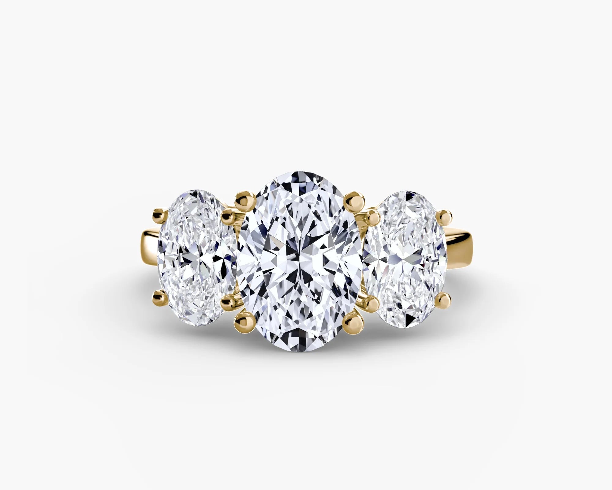 Three-stone diamond ring with gold setting on a white background