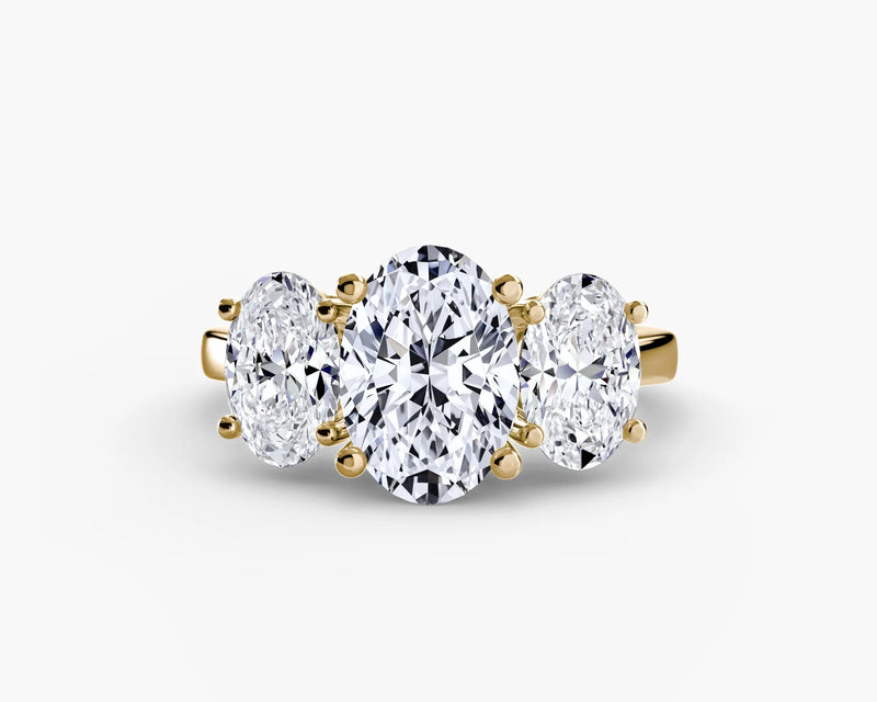 Three-stone diamond ring with gold setting on a white background
