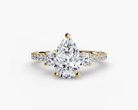 yellow gold ring with a large diamond and smaller diamonds on the band against a white background