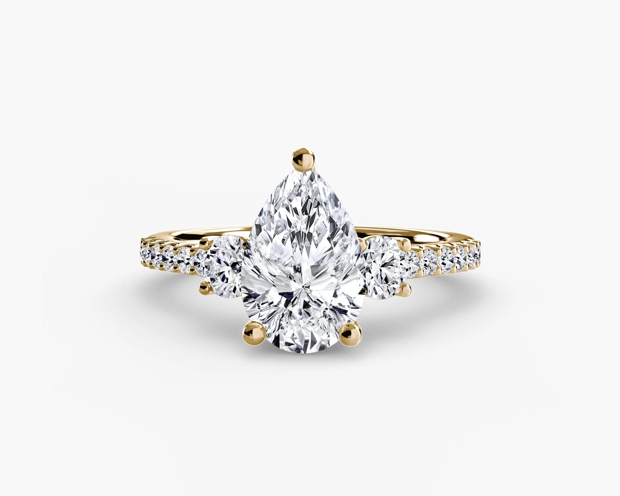 yellow gold ring with a large diamond and smaller diamonds on the band against a white background
